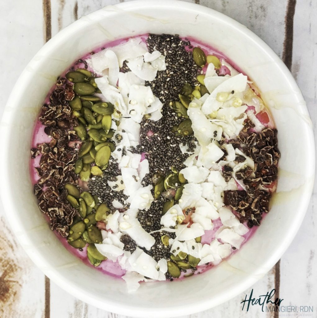Cherry Smoothie Bowl Topped with Chia Seeds, Cocoa Nibs, Coconut and Pumpkin Seeds.