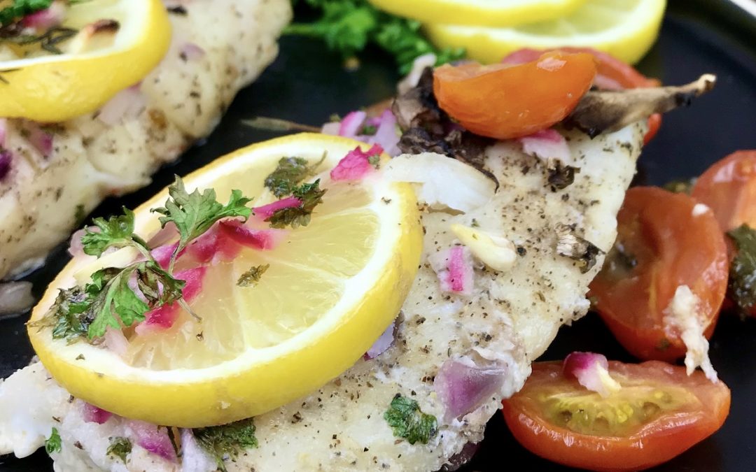 This lemon baked cod recipe is super to prepare and makes a great family meal. This recipe uses with ~14 ounces of raw cod. You can buy a fresh cod fillet, or you can buy frozen, pre-portioned fillets. If you use frozen, you’ll want to defrost the fish first. While the oven is pre-heating, get all of the ingredients measured and prepared. The recipe incorporated quite a few vegetables and herbs that need cut in advance. Slice the cherry tomatoes and mushrooms, then chop the onions, garlic and fresh parsley. You’ll also need butter, lemon juice and a fresh lemon. Prepare and measure these ingredients, then set them aside. To start, preheat oven to 400 degrees. Spray a baking dish with cooking spray, then set it aside and prepare the fish. If you are using a fresh cod fillet, slice it into 4 equal fillets, ~3.5 ounces each. Pat it dry, then sprinkle with salt and pepper. Transfer the cod fillets to a baking dish, then top with the sliced mushrooms and cherry tomatoes. Melt the butter in a small bowl, then add the lemon juice, onions, garlic and parsley. Stir those ingredients together well, then pour over the fillets. If you have a fresh lemon, lay a slice top of each fillet and sprinkle with additional parsley. Your fish is ready to bake. Transfer it to the oven and allow it to cook for ~20 minutes or until it is opaque and flakes with a fork. I highly suggest checking it with a food thermometer to be sure it is done. It is fully cooked when the internal temperature reaches ~145 degrees F. This lemon baked cod is great served with rice and a green salad, or your favorite vegetable. I hope you enjoy it.