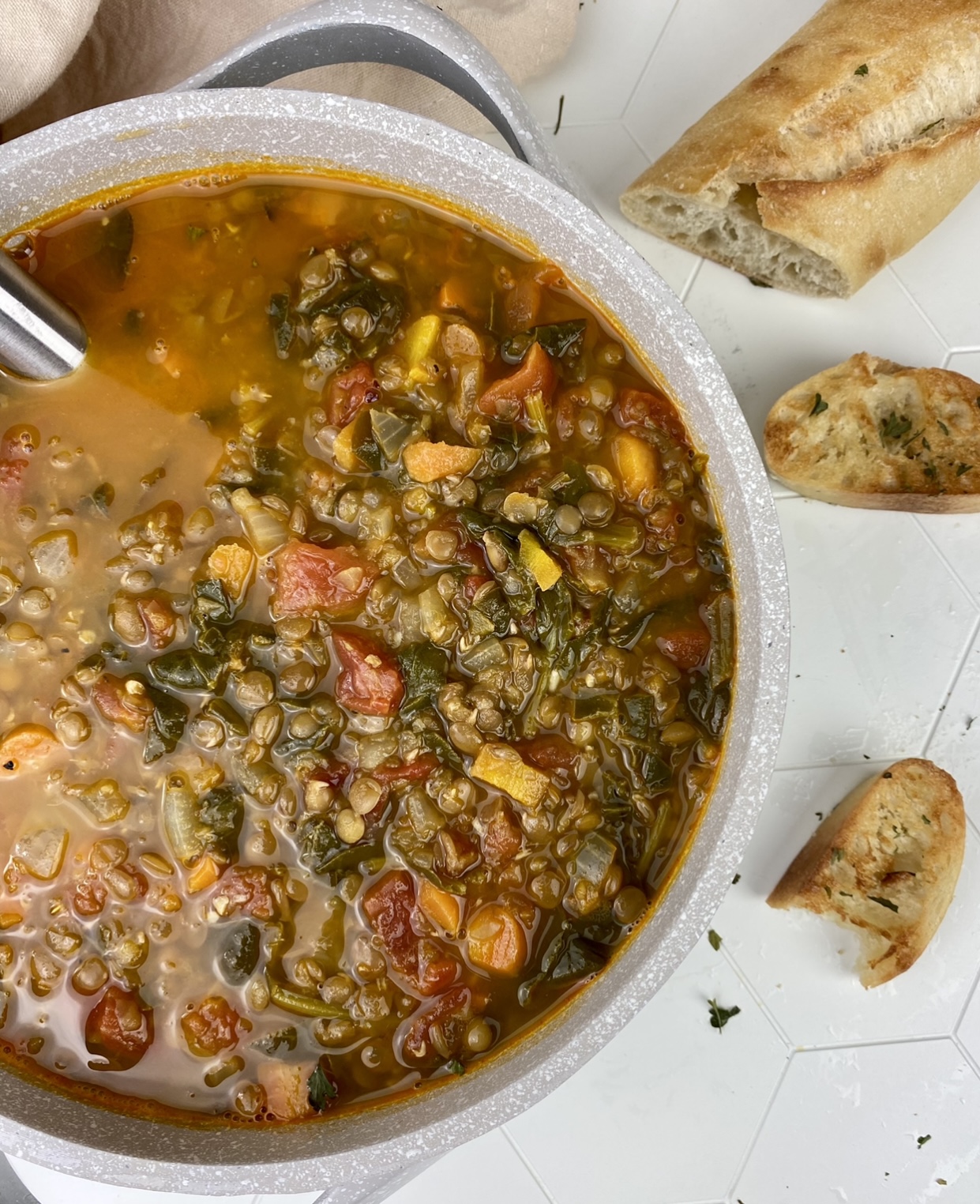 Photo of a large pot of hearty lentil soup that shows the ingredients