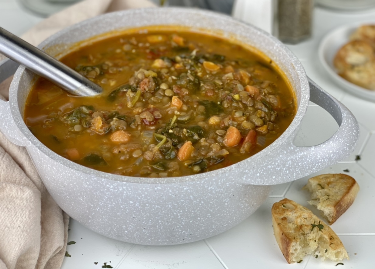 Photo of a large pot of hearty lentil soup that shows the ingredients